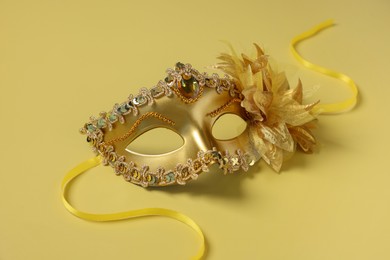 Photo of One beautiful carnival mask on yellow background