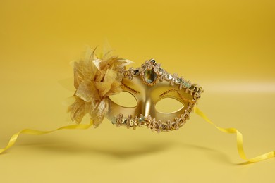 Beautiful carnival mask in air on yellow background