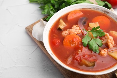 Delicious homemade stew in bowl on light table, closeup