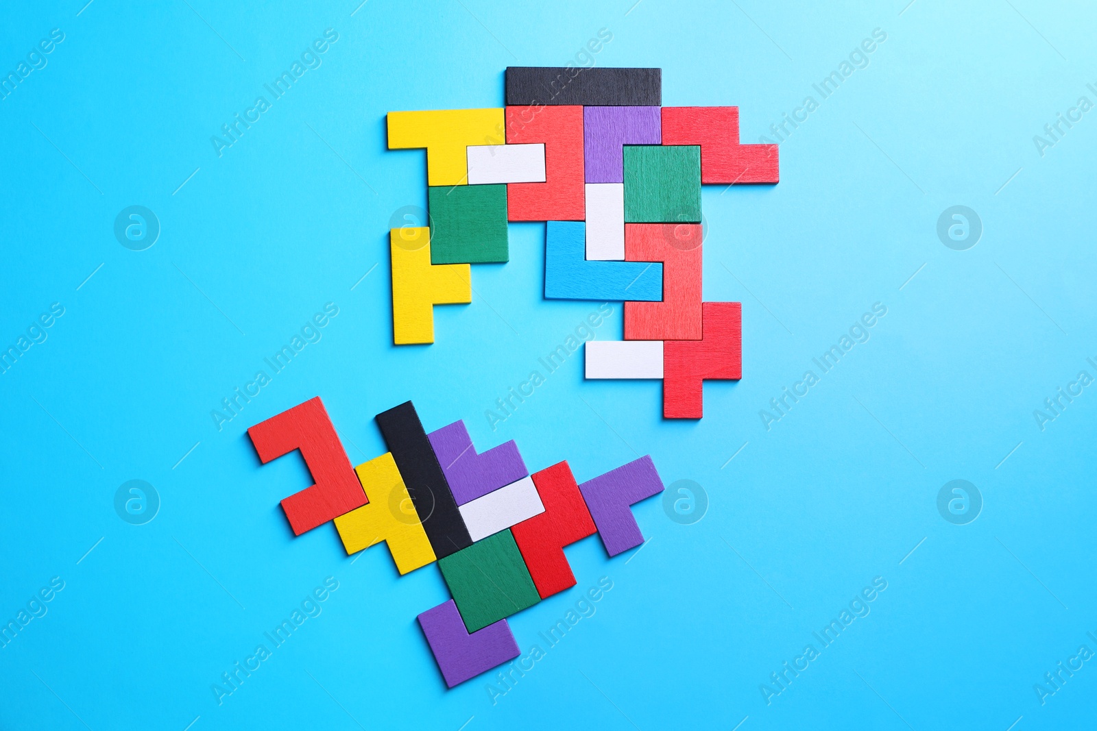 Photo of Colorful wooden puzzle pieces on light blue background, top view