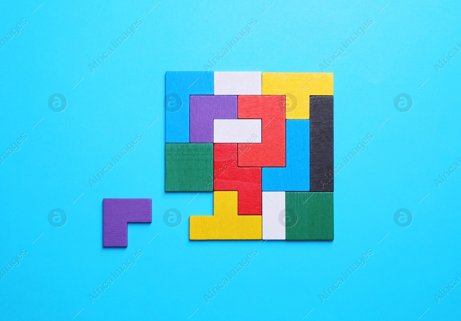 Photo of Colorful wooden puzzle pieces on light blue background, top view