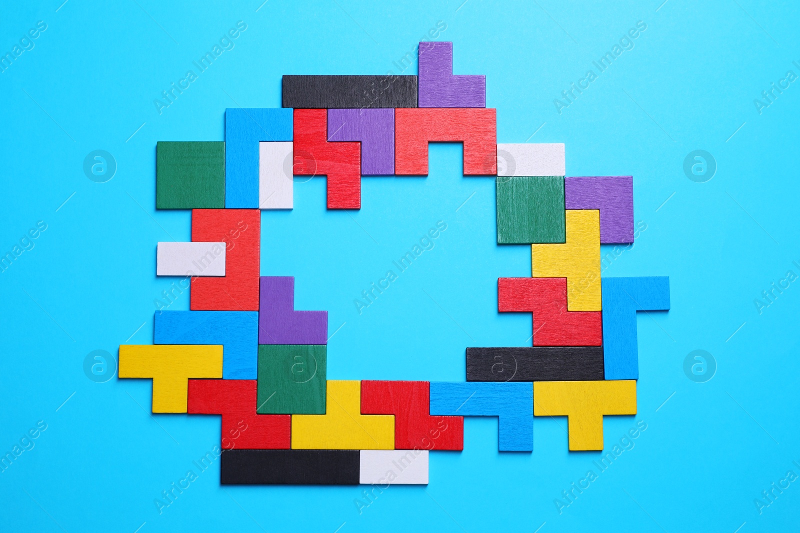 Photo of Colorful wooden puzzle pieces on light blue background, top view