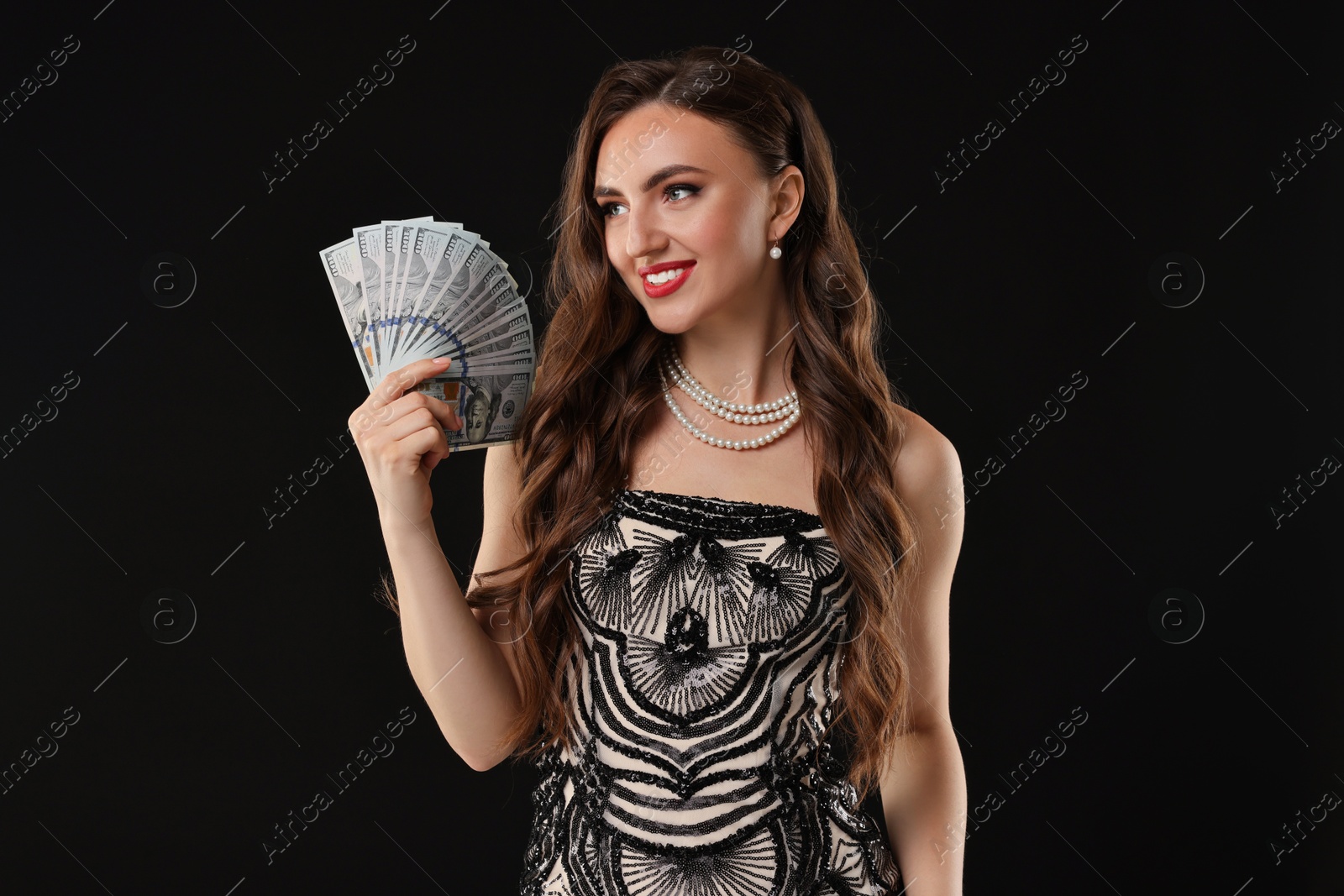 Photo of Smiling woman with dollar banknotes on black background