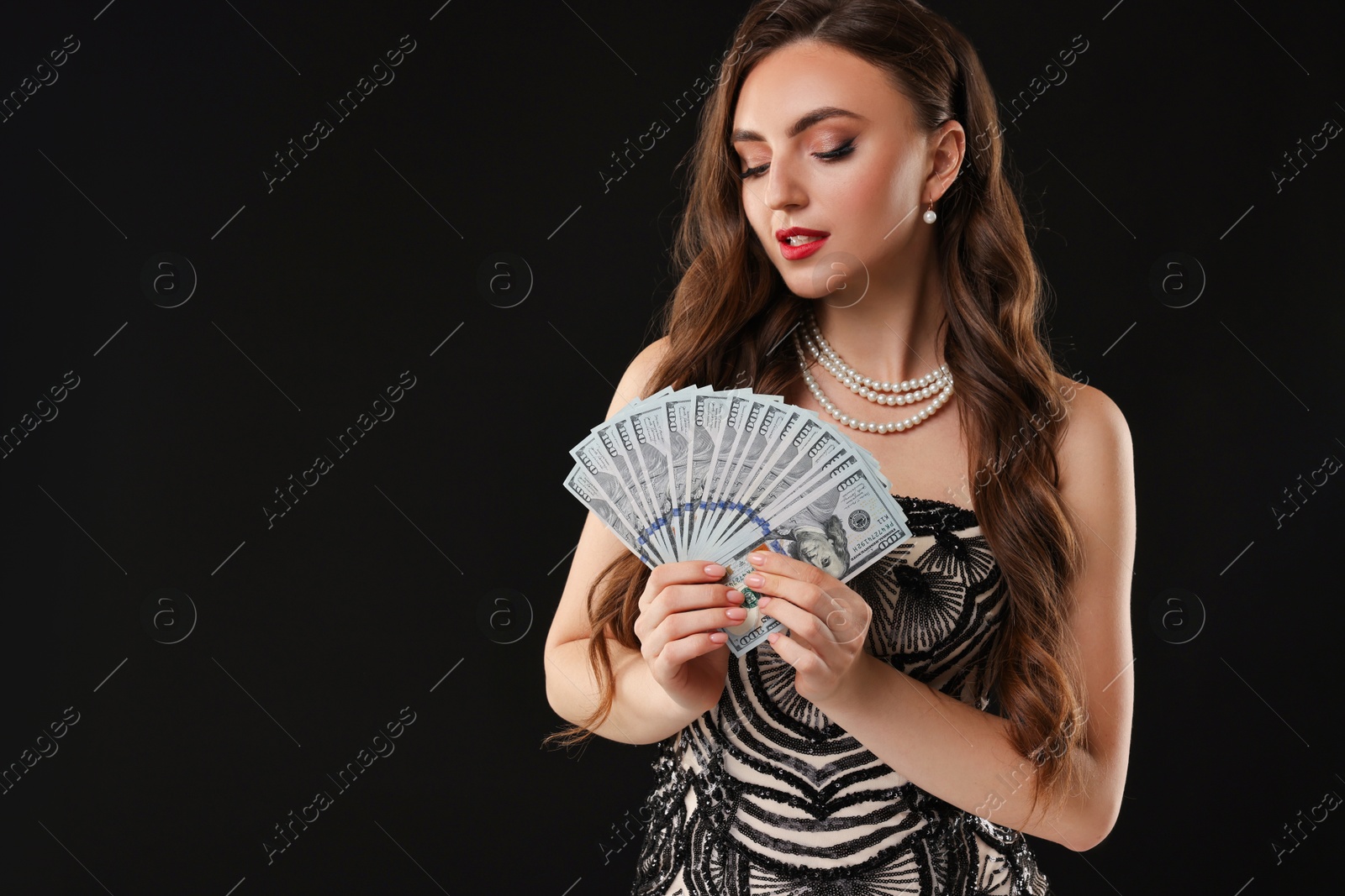 Photo of Charming woman with dollar banknotes on black background. Space for text