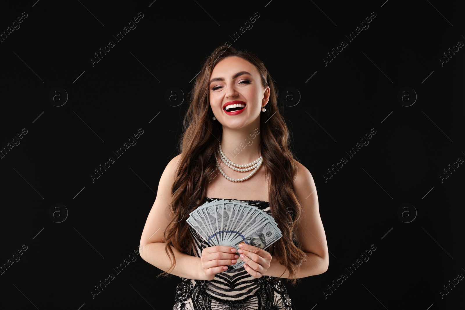 Photo of Happy woman with dollar banknotes on black background