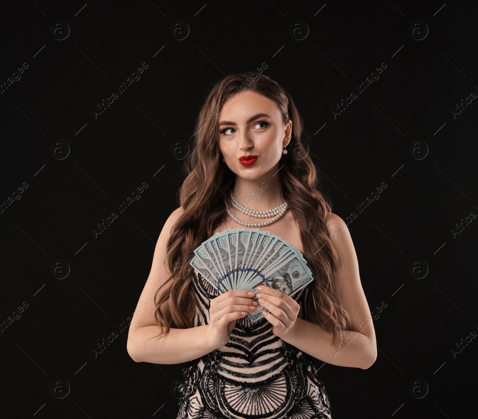 Photo of Charming woman with dollar banknotes on black background. Space for text