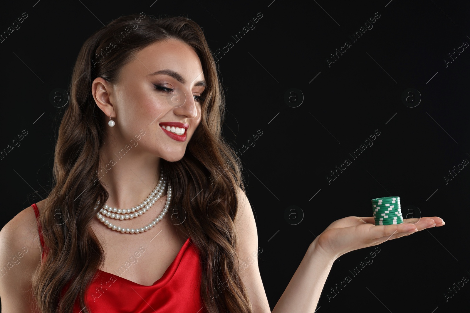 Photo of Smiling woman with poker chips on black background