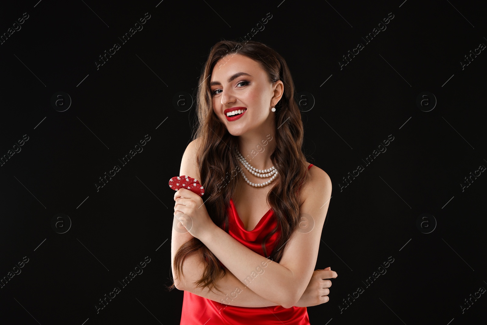 Photo of Smiling woman with poker chips on black background