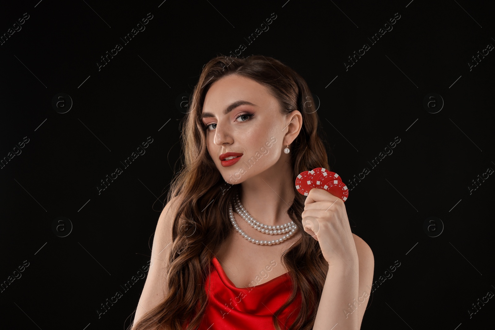 Photo of Charming woman with poker chips on black background