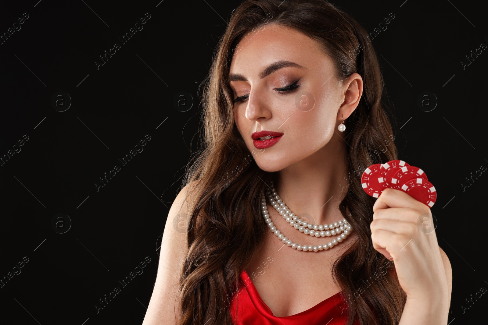 Photo of Charming woman with poker chips on black background. Space for text