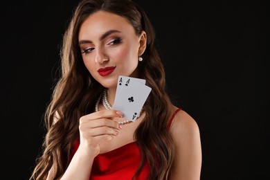 Photo of Poker game. Charming woman with playing cards on black background