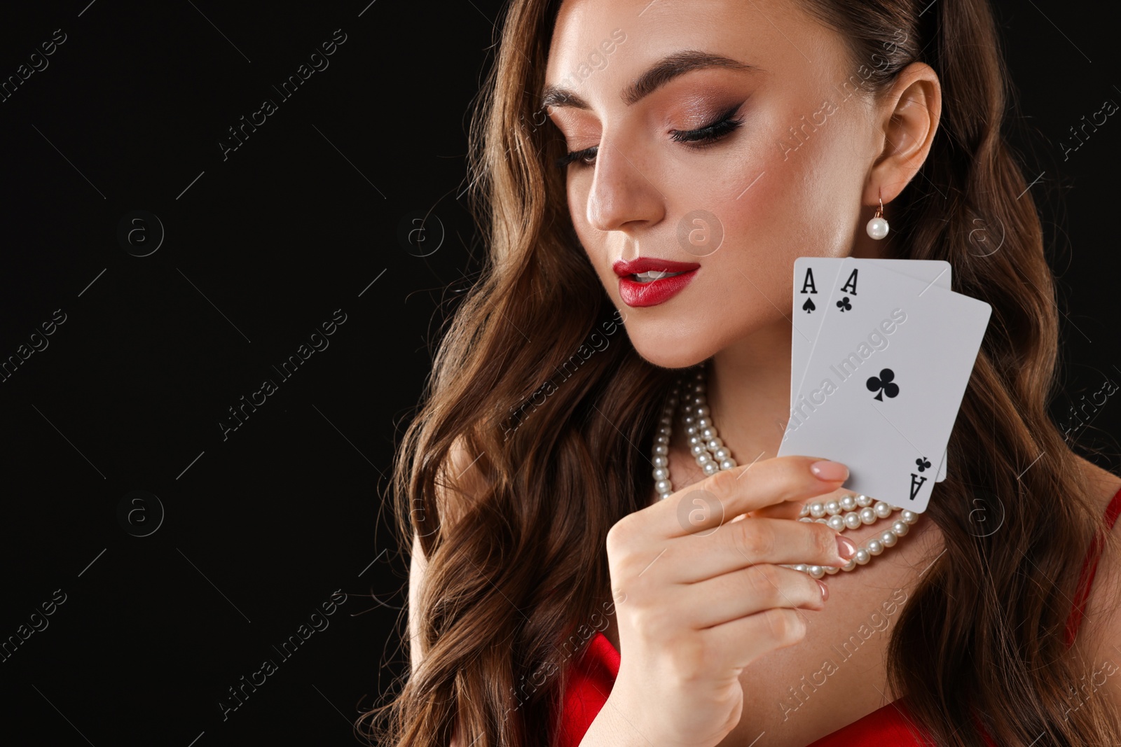 Photo of Poker game. Charming woman with playing cards on black background. Space for text