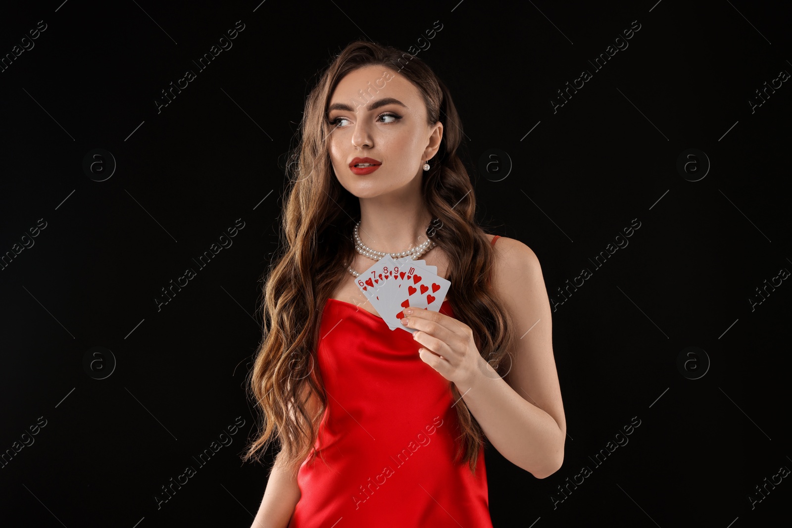 Photo of Poker game. Charming woman with playing cards on black background