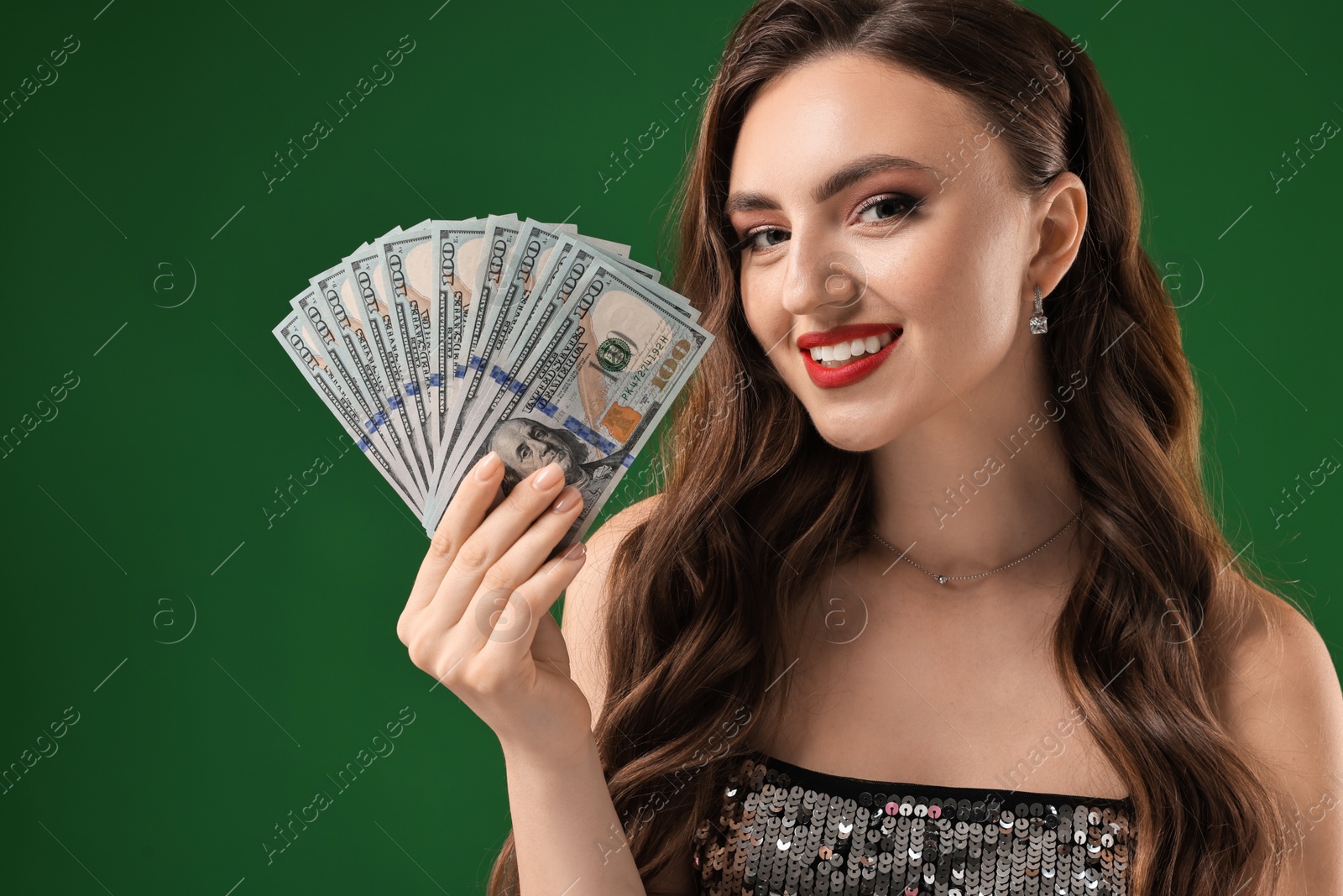 Photo of Smiling woman with dollar banknotes on green background