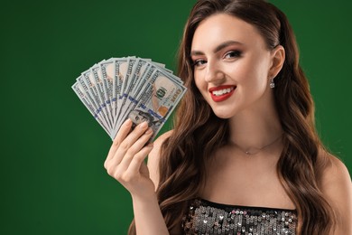 Photo of Smiling woman with dollar banknotes on green background