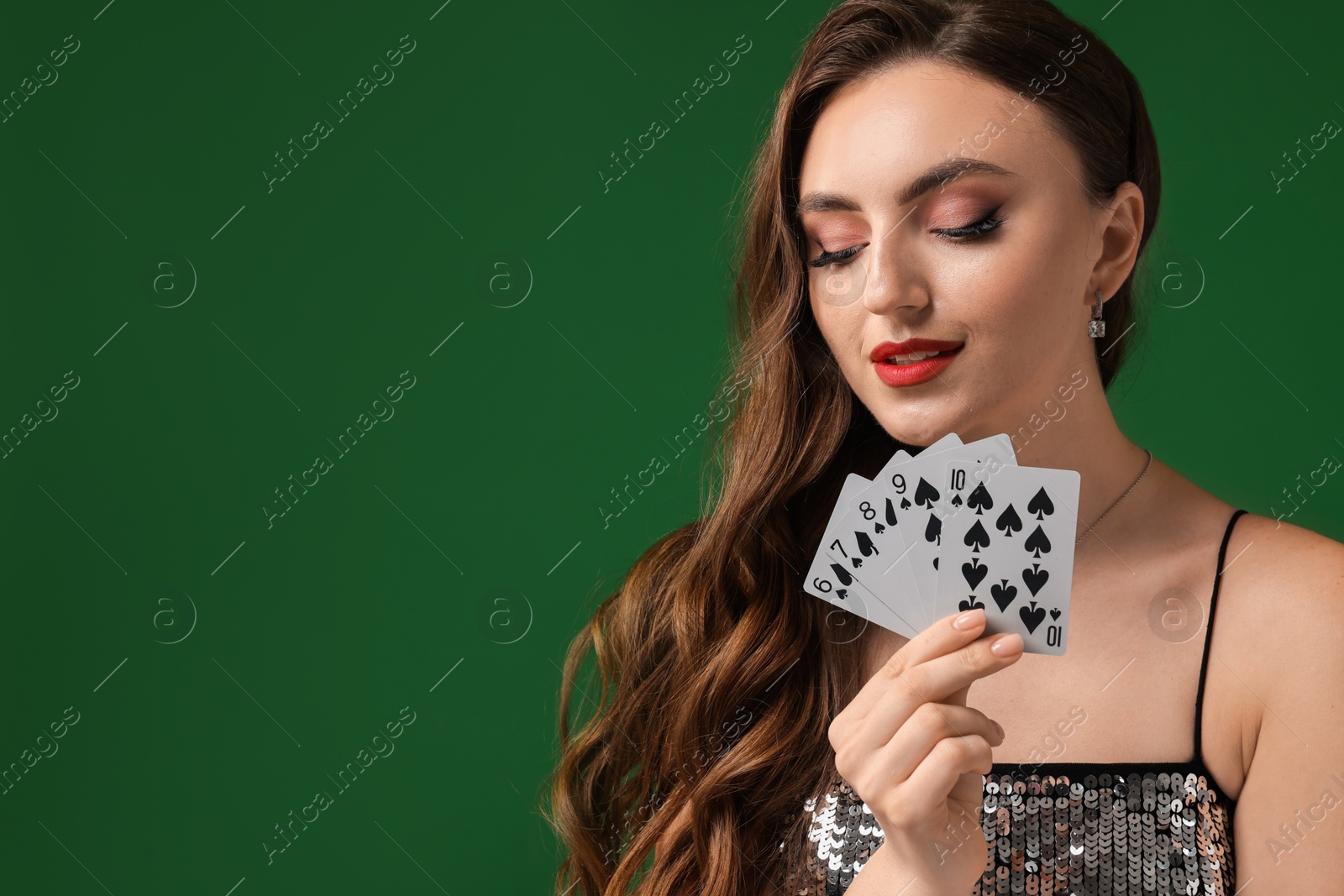 Photo of Poker game. Charming woman with playing cards on green background. Space for text