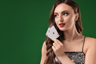 Poker game. Charming woman with playing cards on green background. Space for text