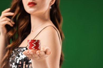 Woman with poker chips on green background, closeup. Space for text