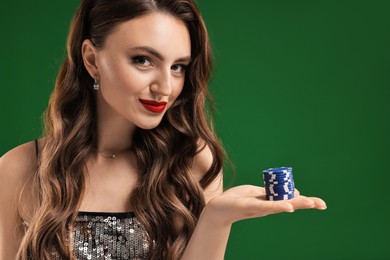 Photo of Charming woman with poker chips on green background