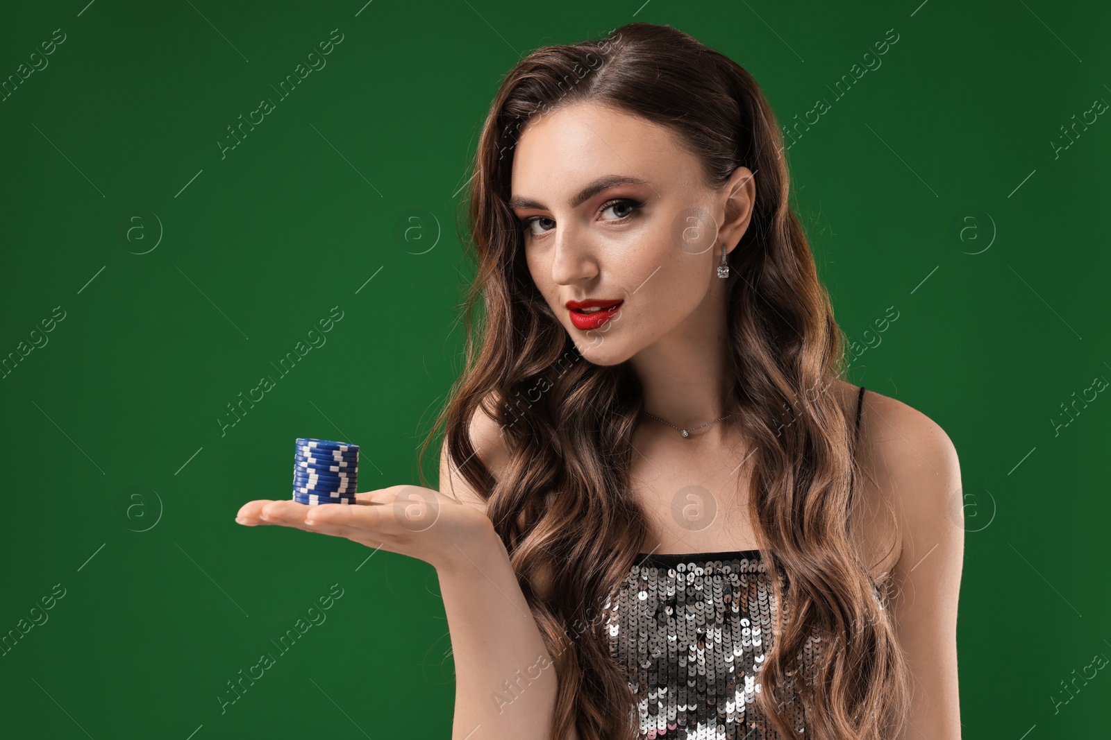 Photo of Charming woman with poker chips on green background