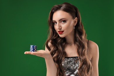 Charming woman with poker chips on green background