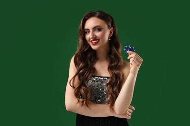 Smiling woman with poker chips on green background