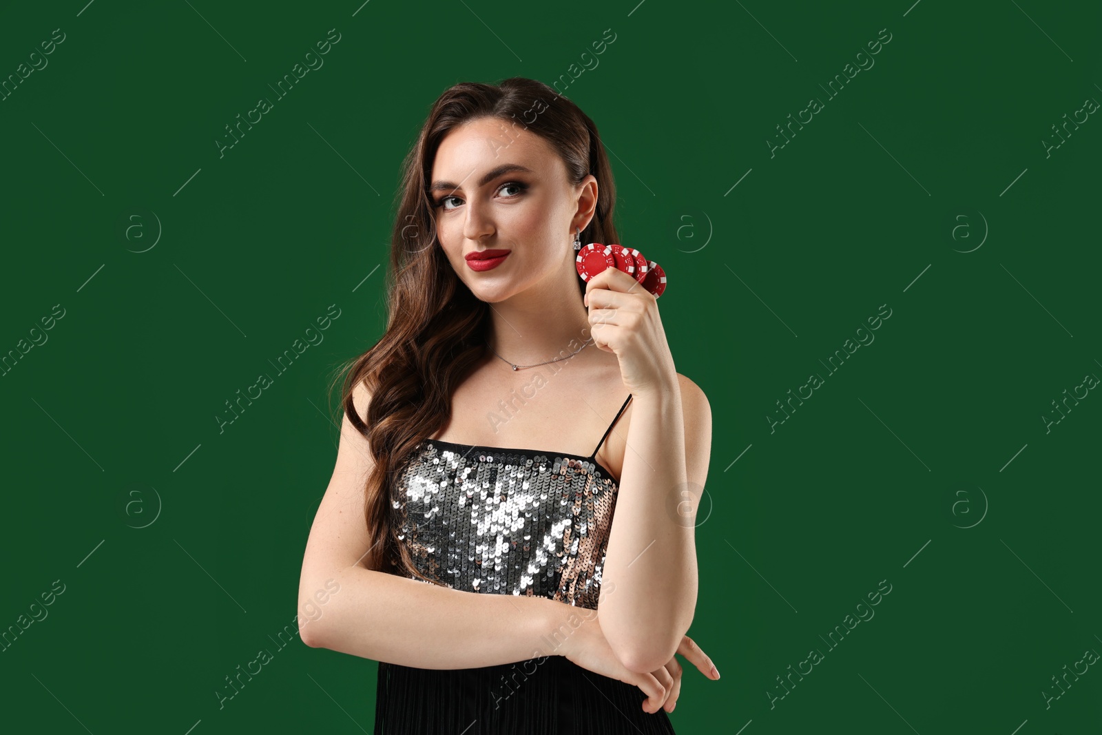 Photo of Charming woman with poker chips on green background