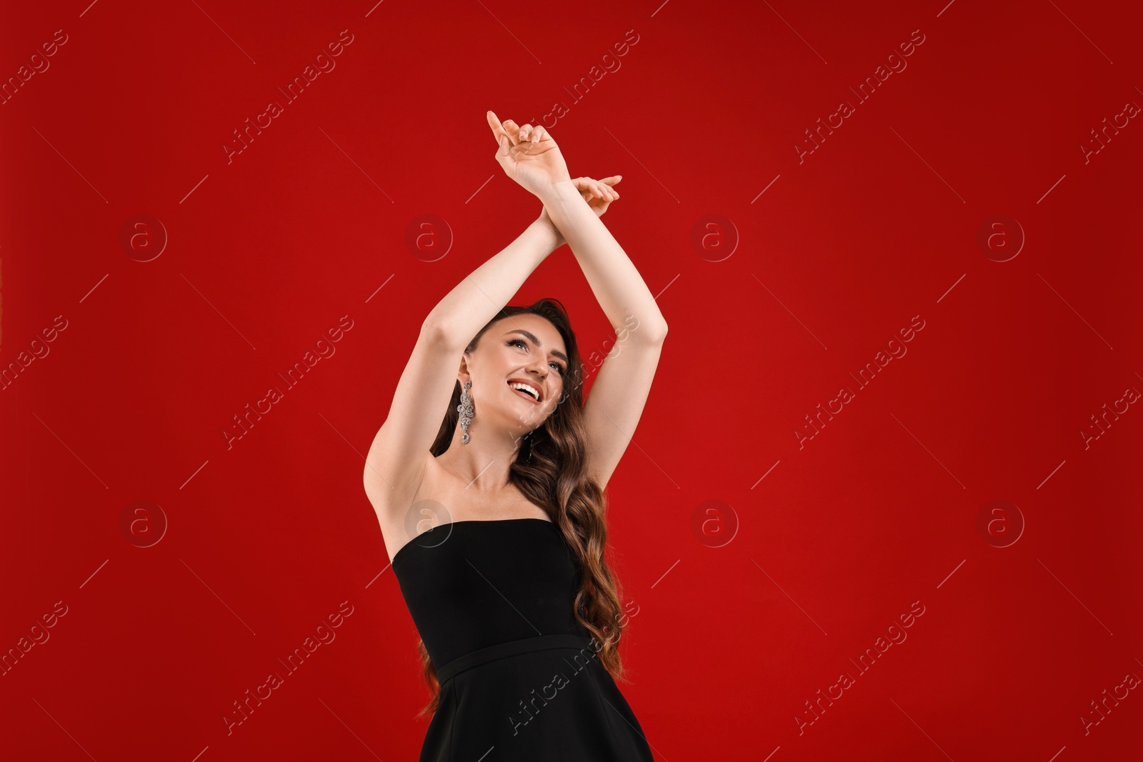 Photo of Portrait of smiling woman dancing on red background