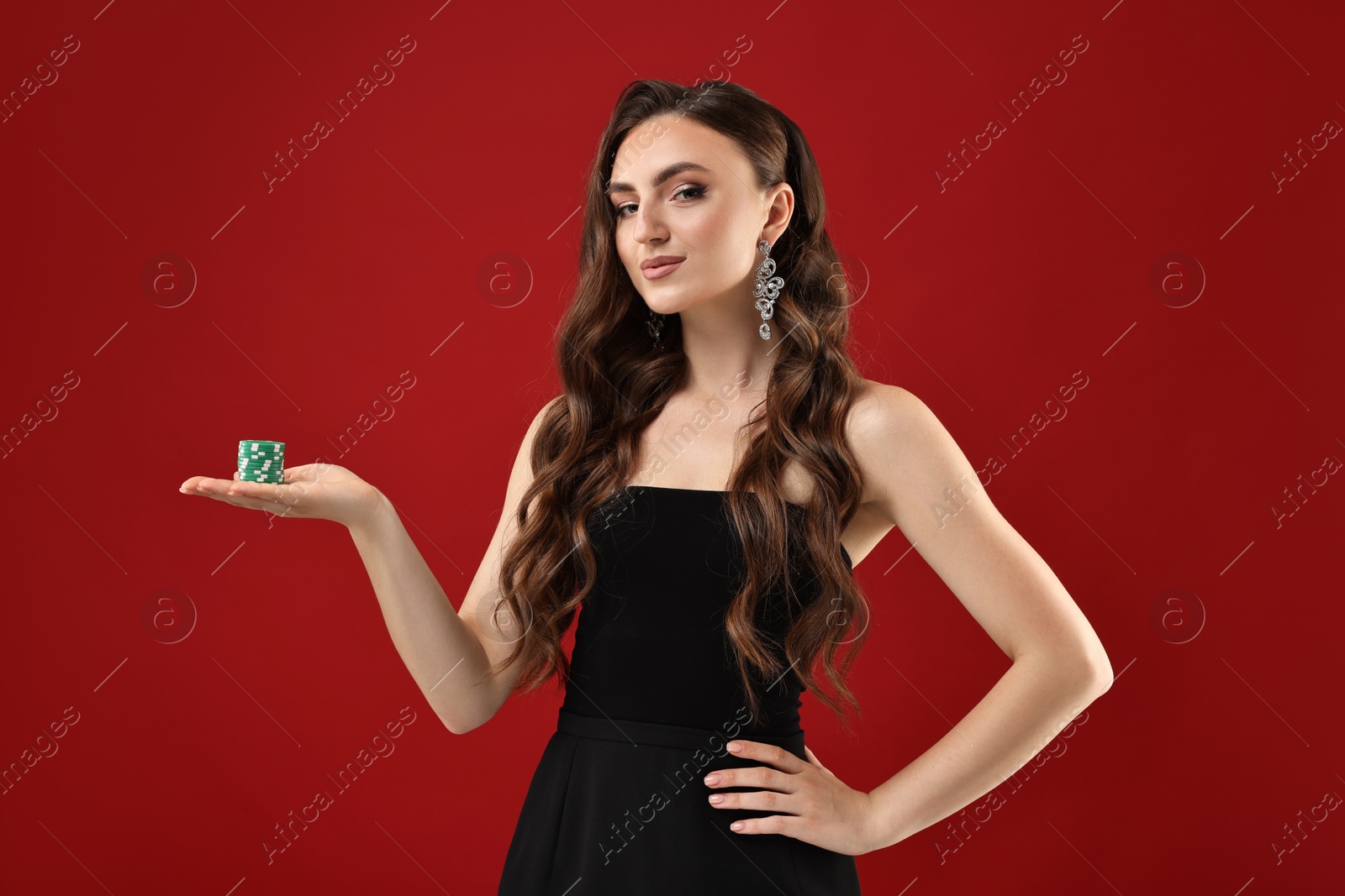 Photo of Charming woman with poker chips on red background