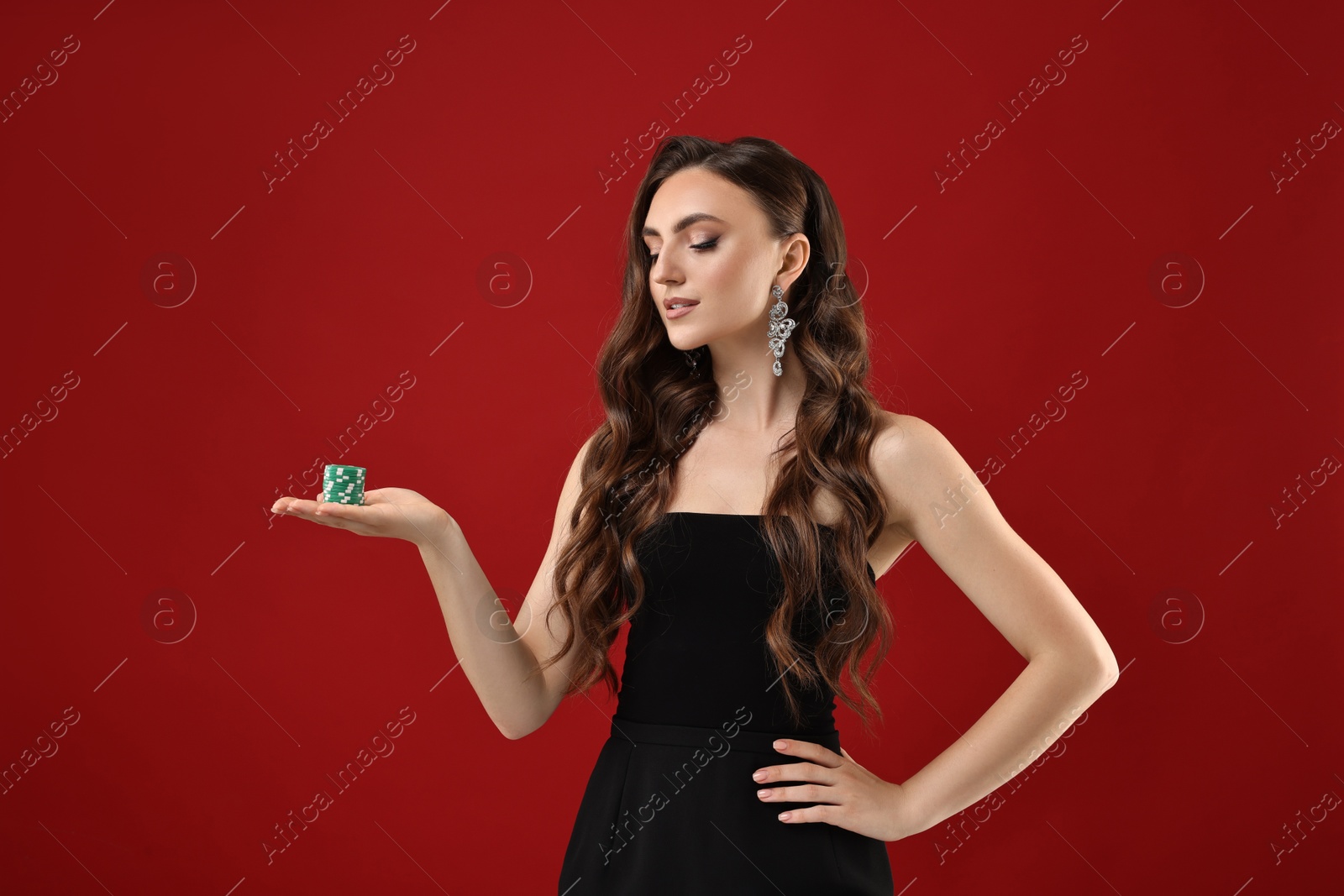 Photo of Charming woman with poker chips on red background