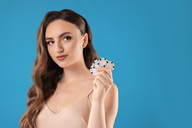 Photo of Charming woman with poker chips on light blue background. Space for text