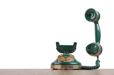 Photo of Green vintage corded telephone on wooden table against light background, space for text