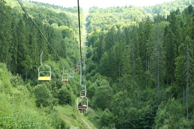 Ski lift and green trees at mountain resort