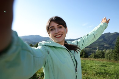 Smiling woman taking selfie in beautiful mountains