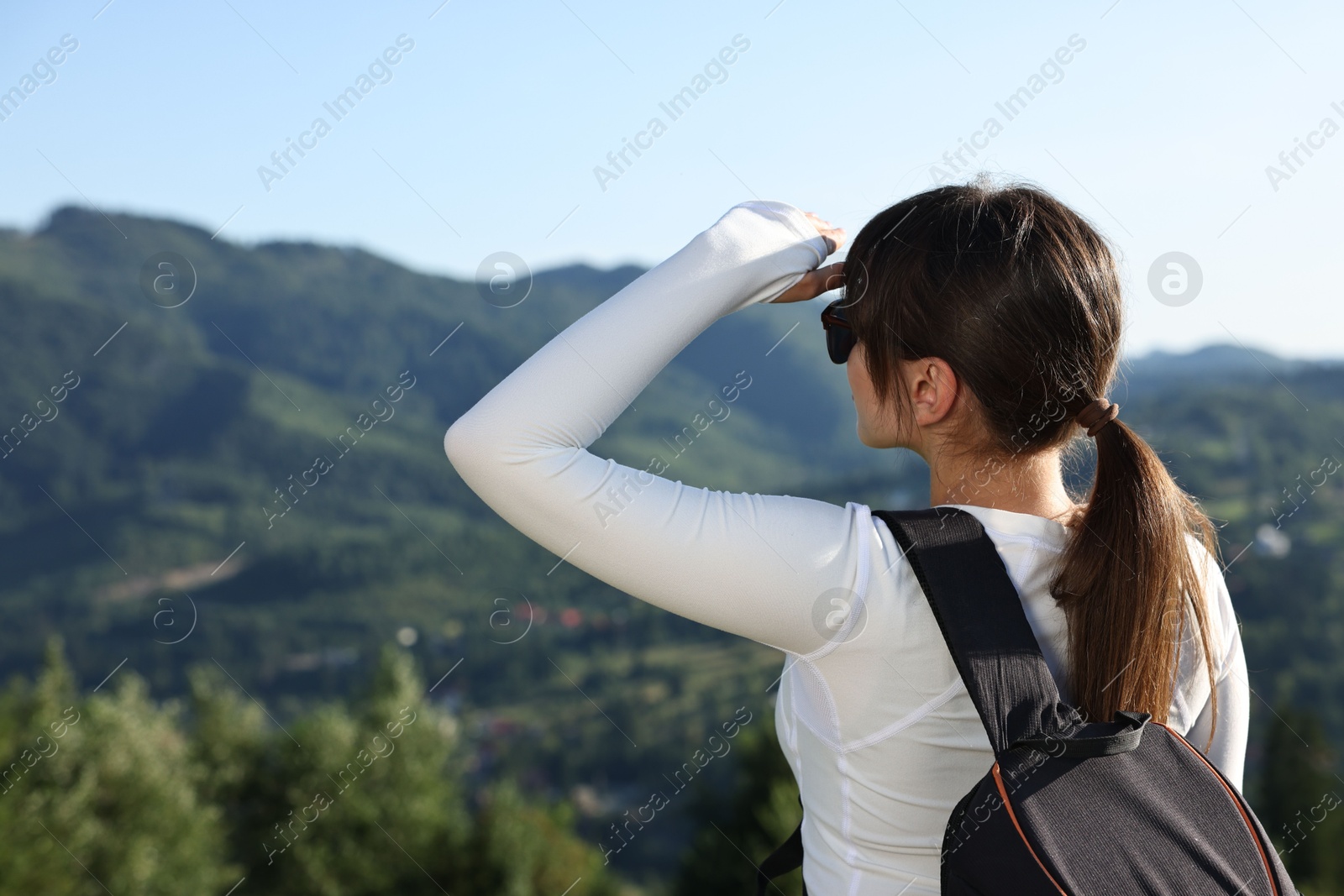 Photo of Young woman in sunglasses with backpack in beautiful mountains