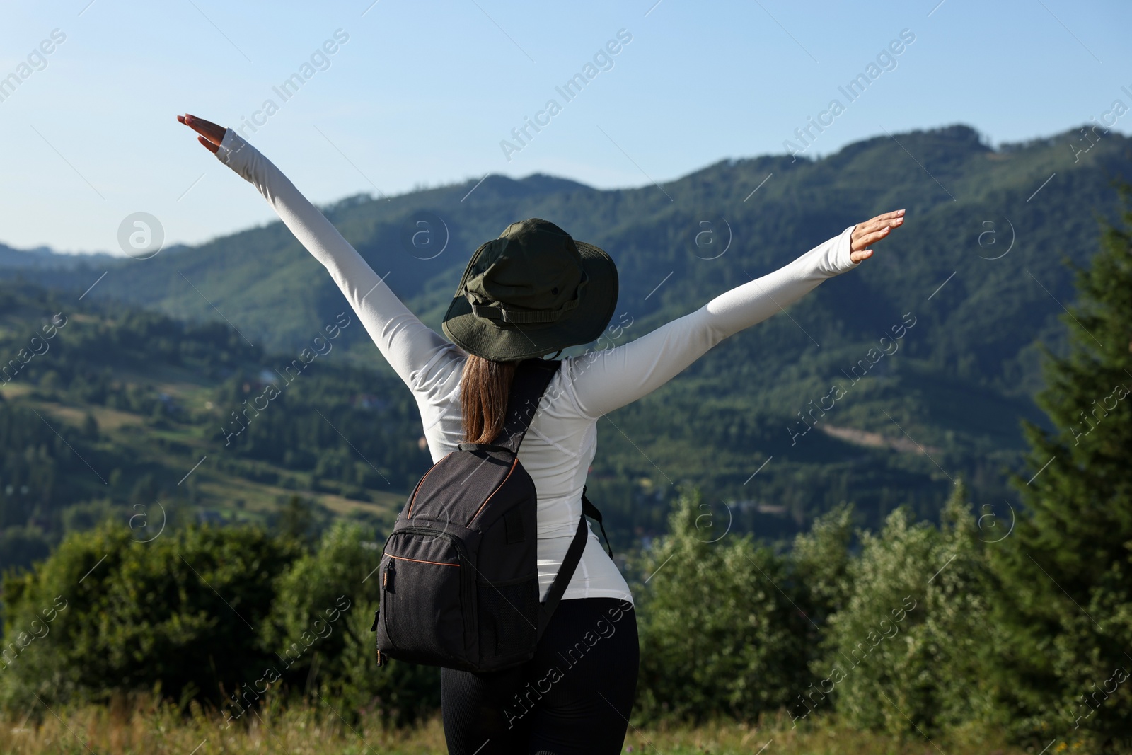 Photo of Woman with backpack in beautiful mountains, back view