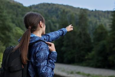 Photo of Woman with backpack in beautiful mountains, space for text