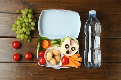 Photo of Lunch box with sandwich, fresh vegetables, cookies, grapes and bottle of water on wooden table, flat lay