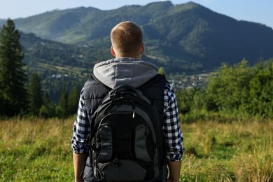 Man with backpack in beautiful mountains, back view