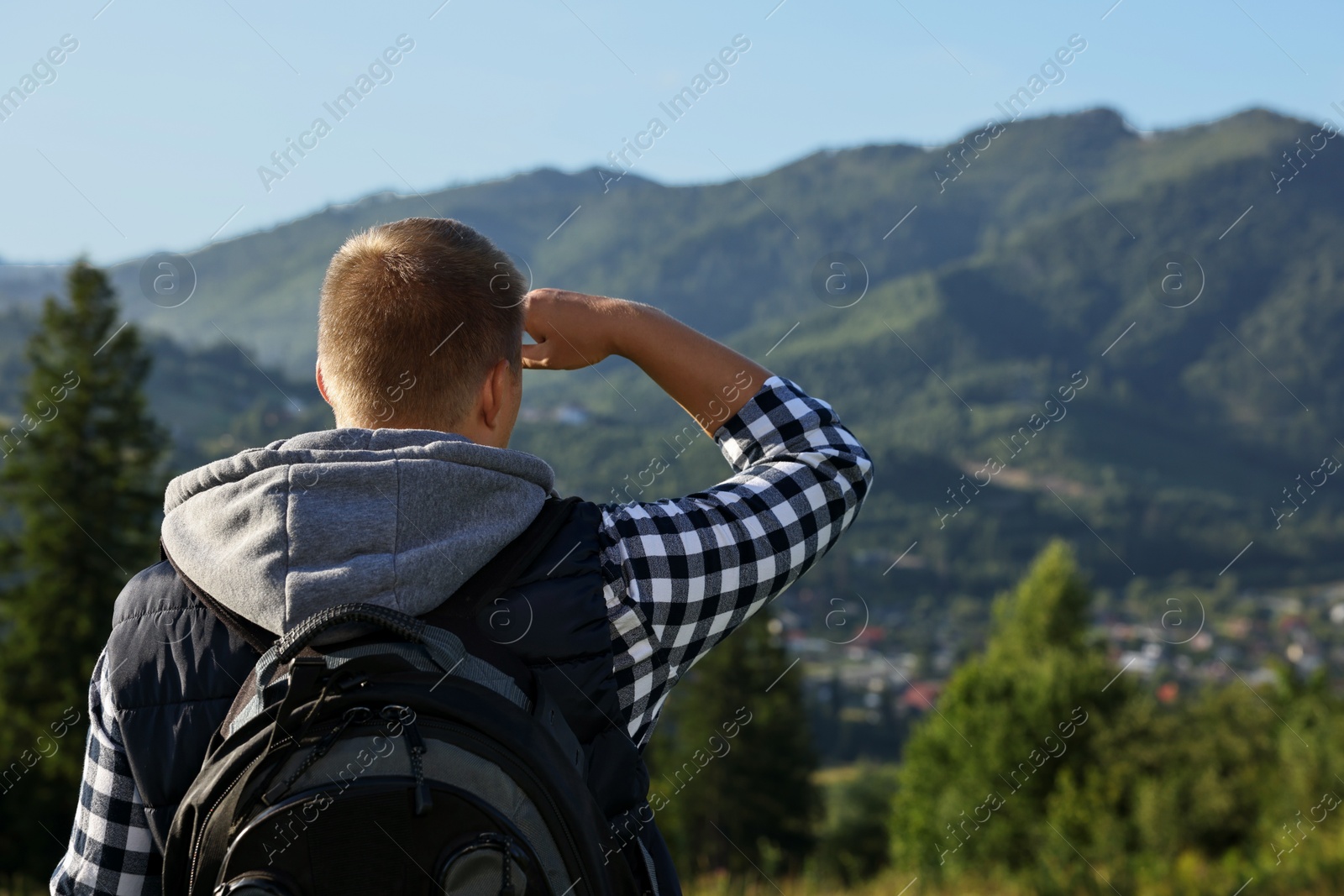 Photo of Man with backpack in beautiful mountains, back view. Space for text