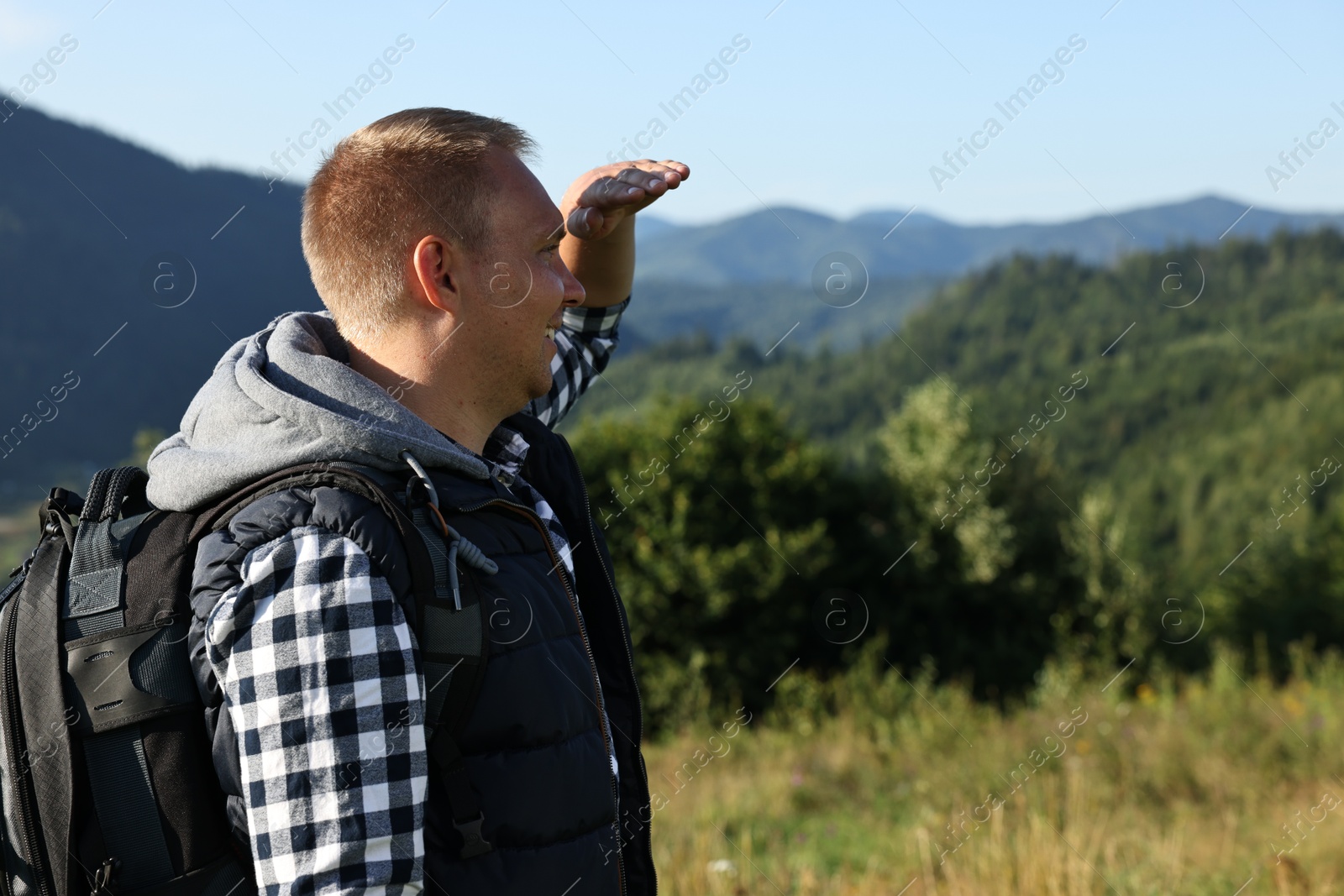 Photo of Man with backpack in beautiful mountains. Space for text