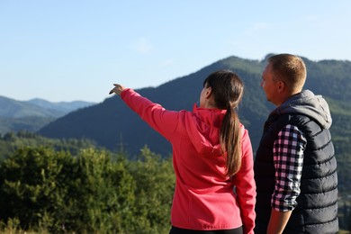 Couple in beautiful mountains on sunny day, back view