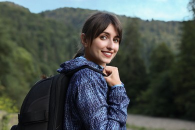 Smiling woman with backpack in beautiful mountains