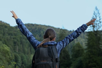 Photo of Woman with backpack in beautiful mountains, back view