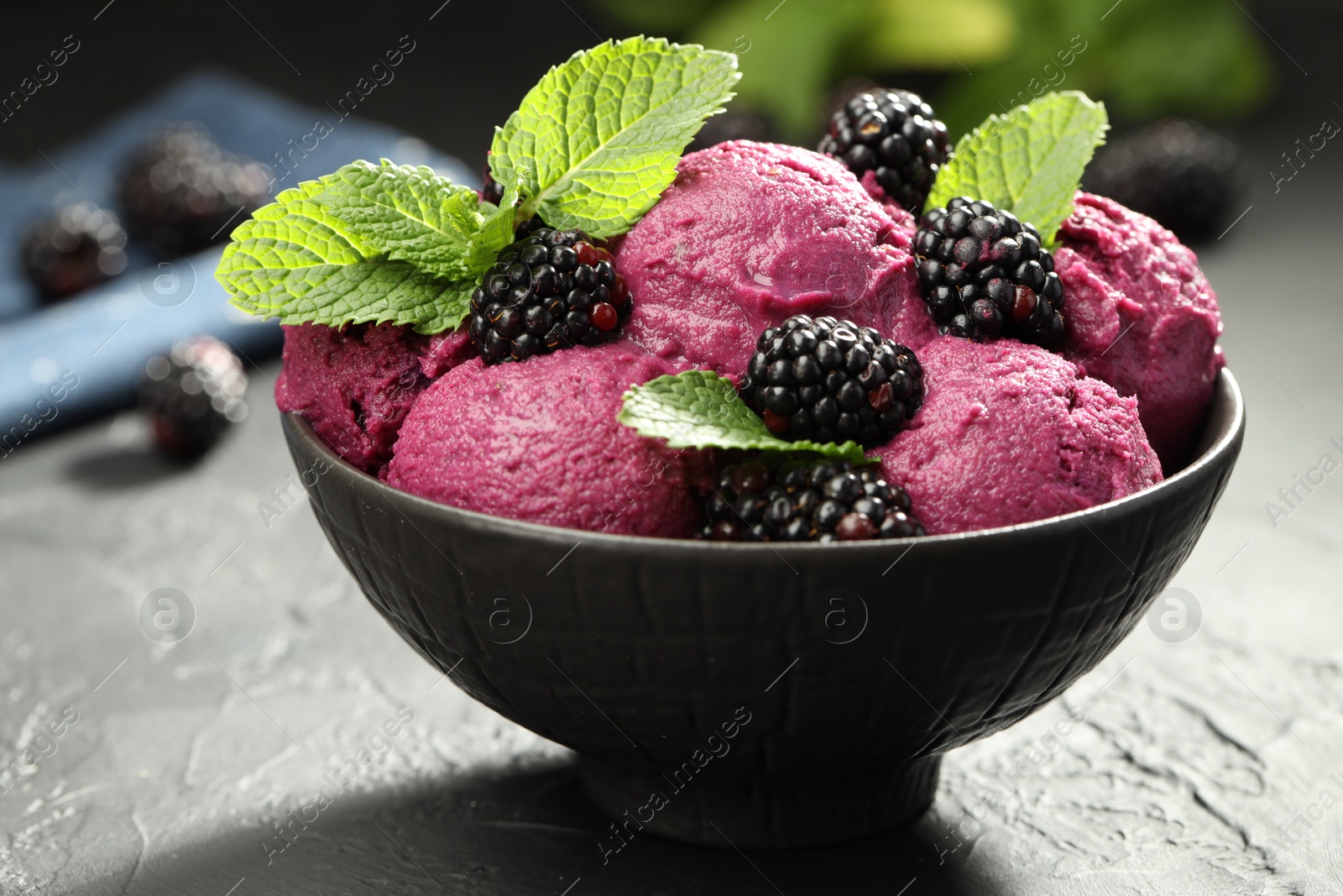 Photo of Delicious blackberry sorbet, fresh berries and mint in bowl on gray textured table, closeup