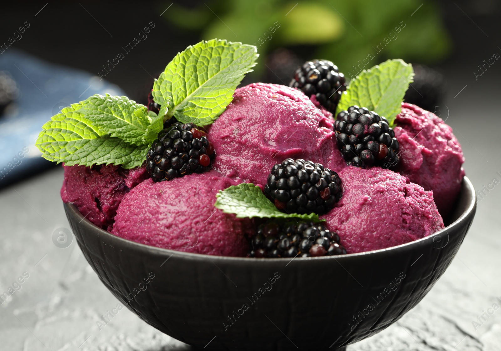 Photo of Delicious blackberry sorbet, fresh berries and mint in bowl on gray table, closeup