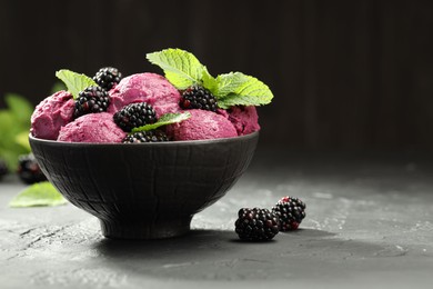 Photo of Delicious blackberry sorbet, fresh berries and mint in bowl on gray textured table, space for text