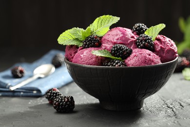 Photo of Delicious blackberry sorbet, fresh berries and mint in bowl on gray textured table