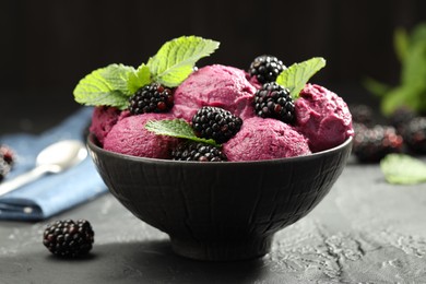 Photo of Delicious blackberry sorbet, fresh berries and mint in bowl on gray textured table, closeup