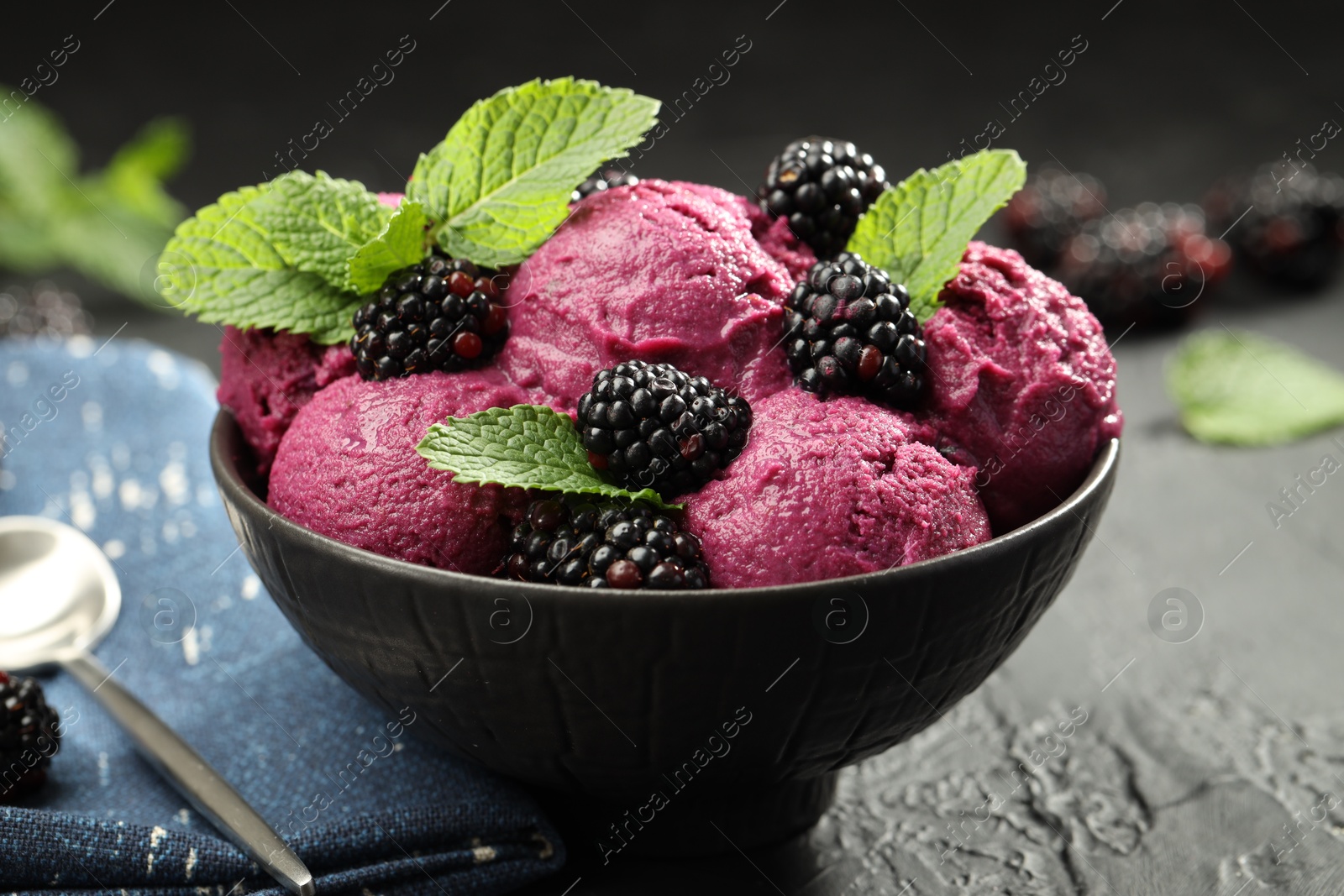 Photo of Delicious blackberry sorbet, fresh berries and mint in bowl served on gray textured table